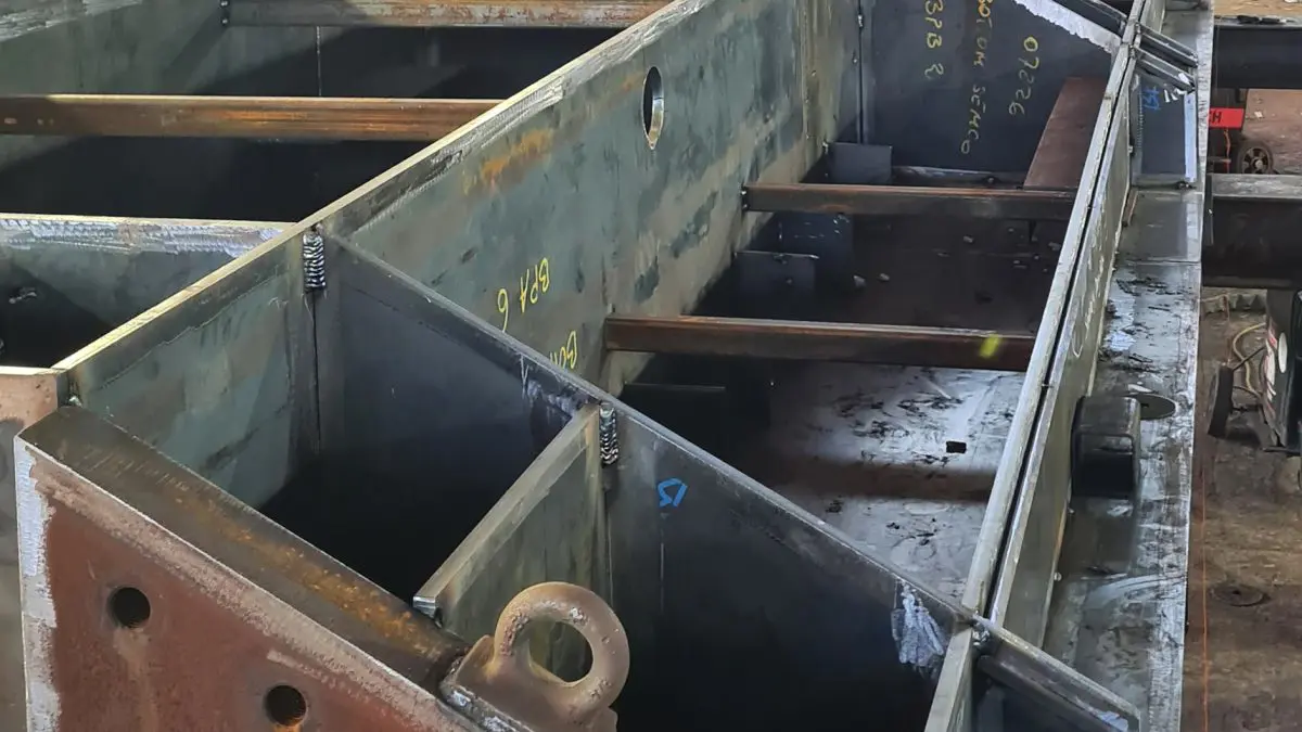 Section of the new Charlestown Harbour lock gate under construction inside a workshop, showing the large steel framework being fabricated